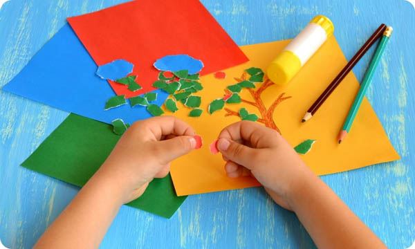 Child Tears a Red Paper into Small Pieces