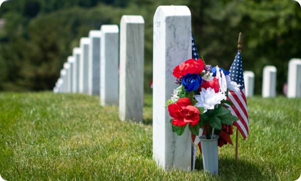 Patriotic Flowers and American Flag Decoration by White Marble Gravestones