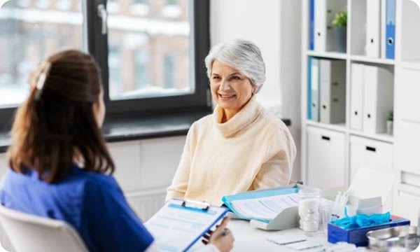 Doctor with Clipboard and Senior Woman at Hospital